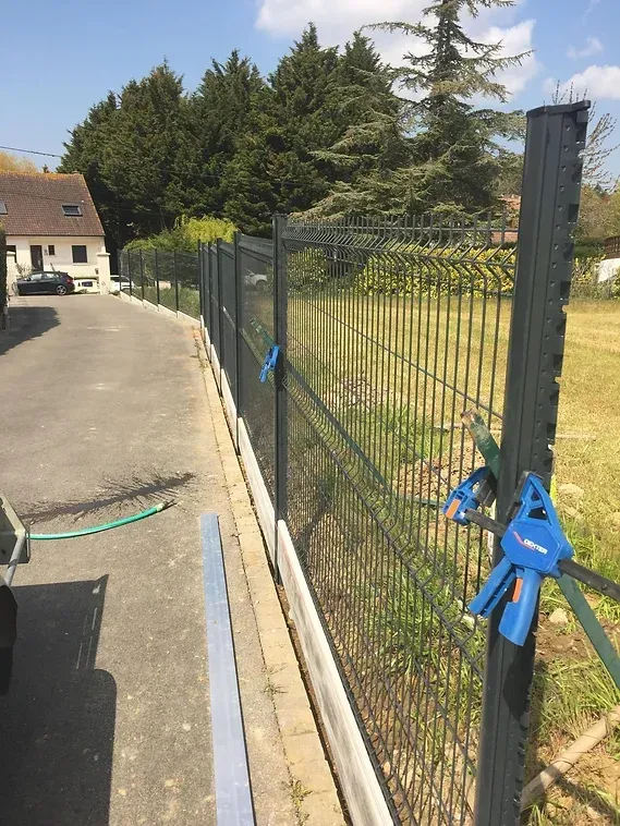 Pose du grillage sur les piquets, ajout de maintients