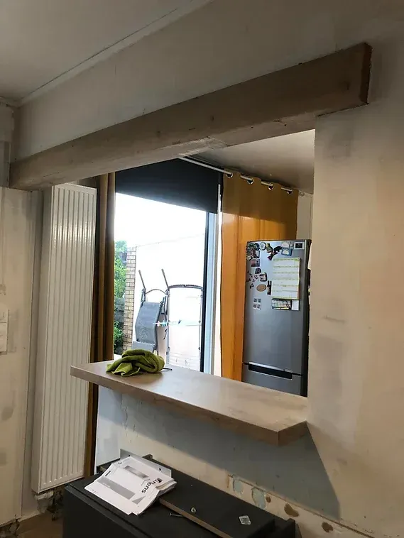 Pose d'une poutre et d'un plan de travail pour l'ouverture entre la cuisine et la salle à manger