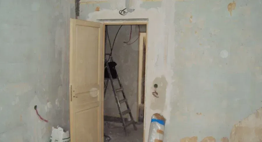 Pièce avec des murs très abîmés et une porte ouverte