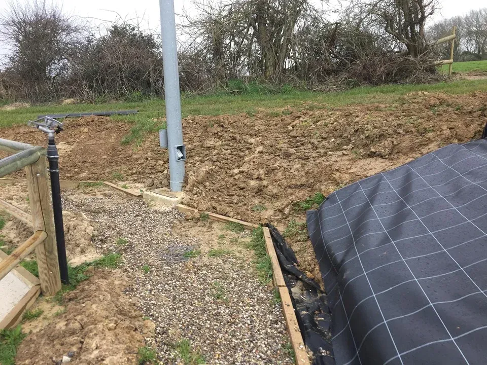 Début de la pose d'une bâche noire