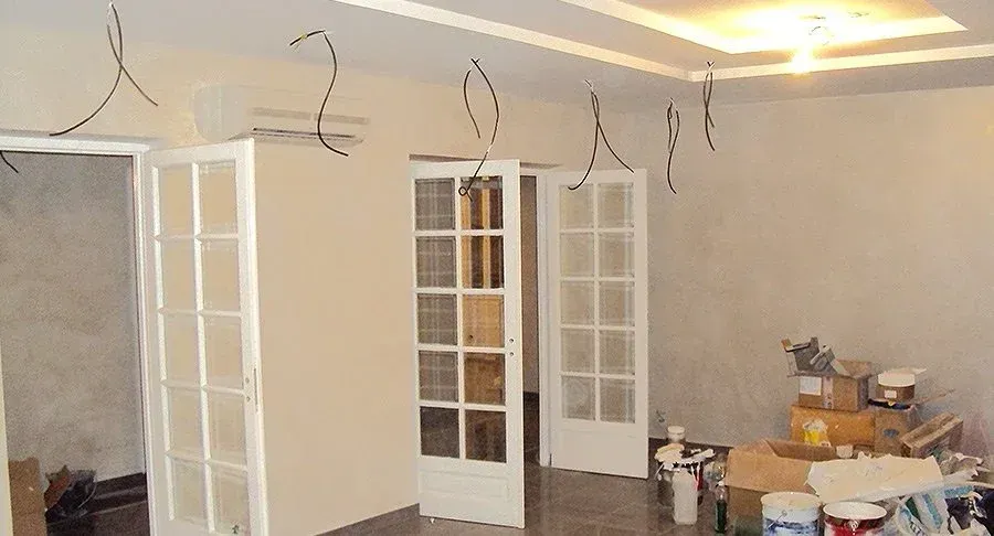 Pièce avec des fils électriques qui pendent et portes vitrées