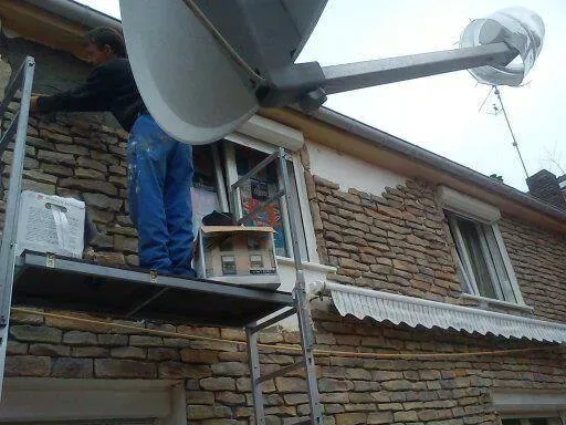 Pose de plaquettes sur une façade avec un échafaudage