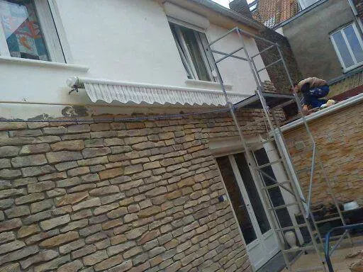 Recouvrement d'une maison blanche avec des pierres