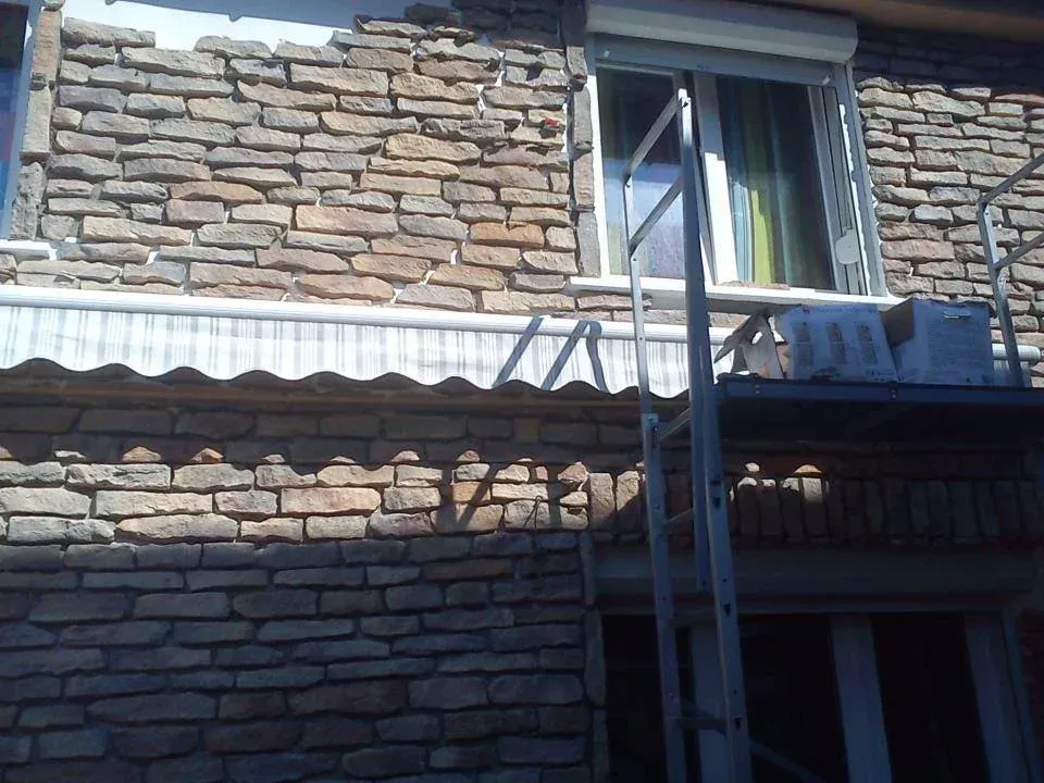 Pose de plaquettes sur une façade sous les toits