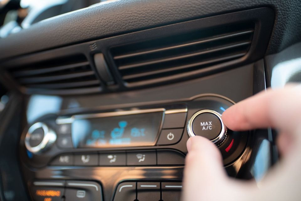 Una persona está ajustando el aire acondicionado de un coche.