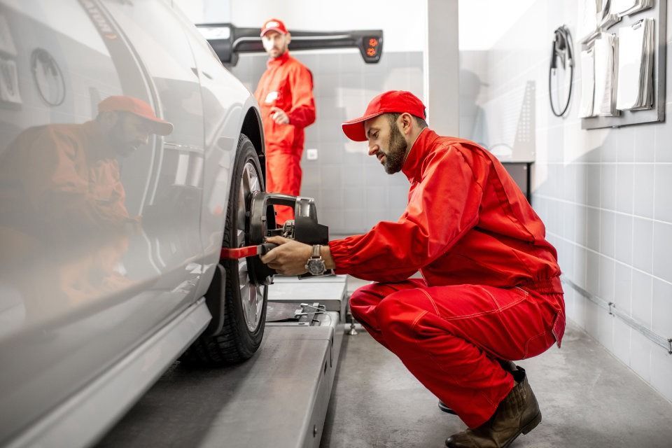 Dos mecánicos están trabajando en un coche en un garaje.