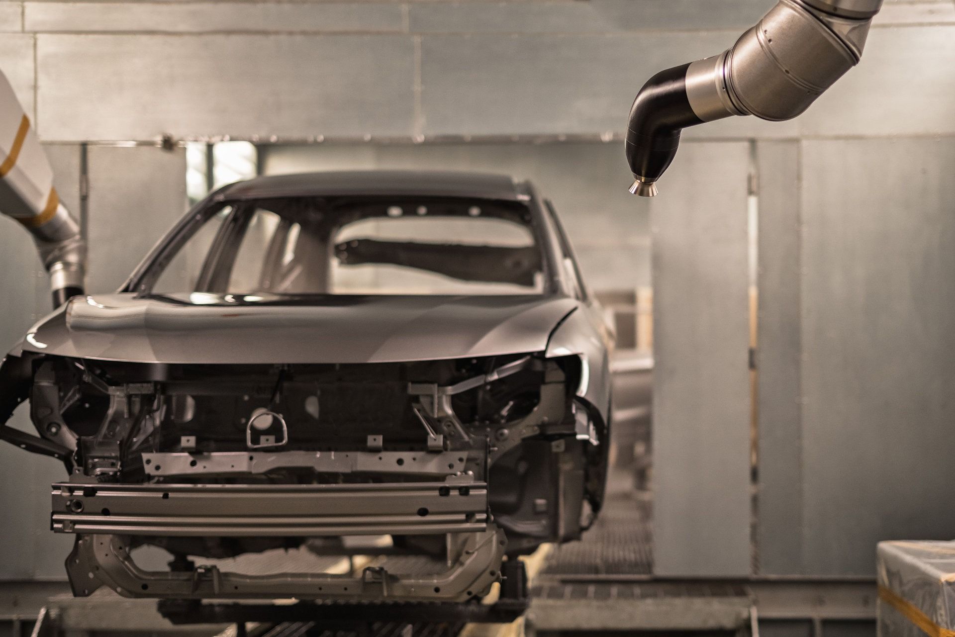 Un coche está siendo pintado por un robot en una fábrica.