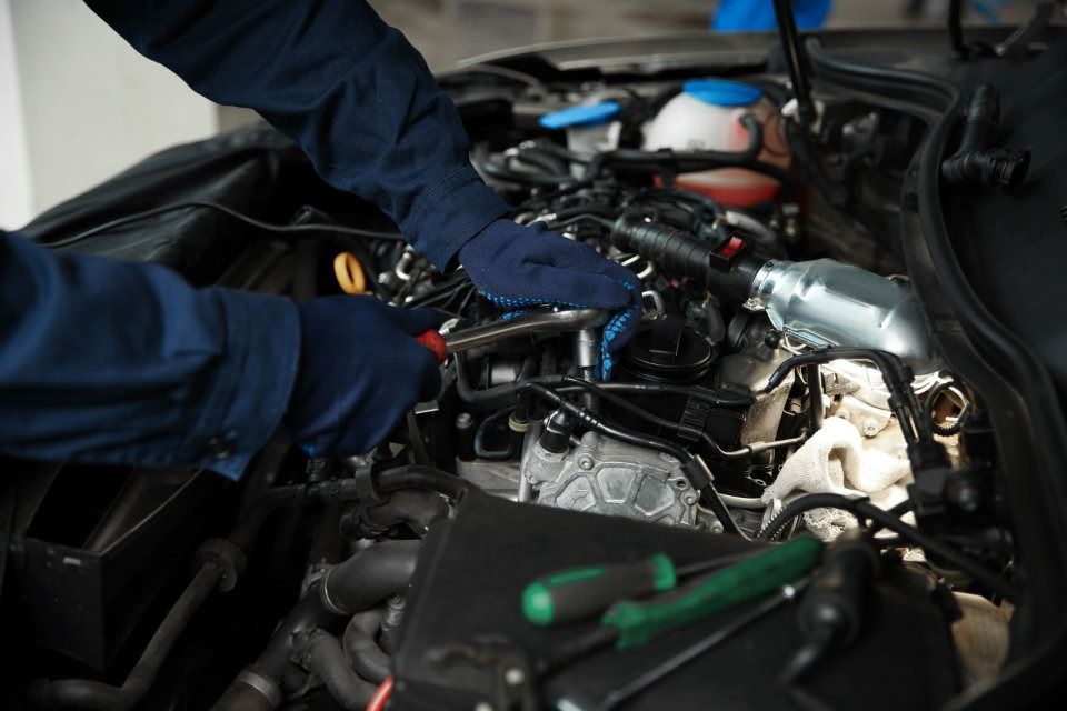Un mecánico está trabajando en el motor de un coche.