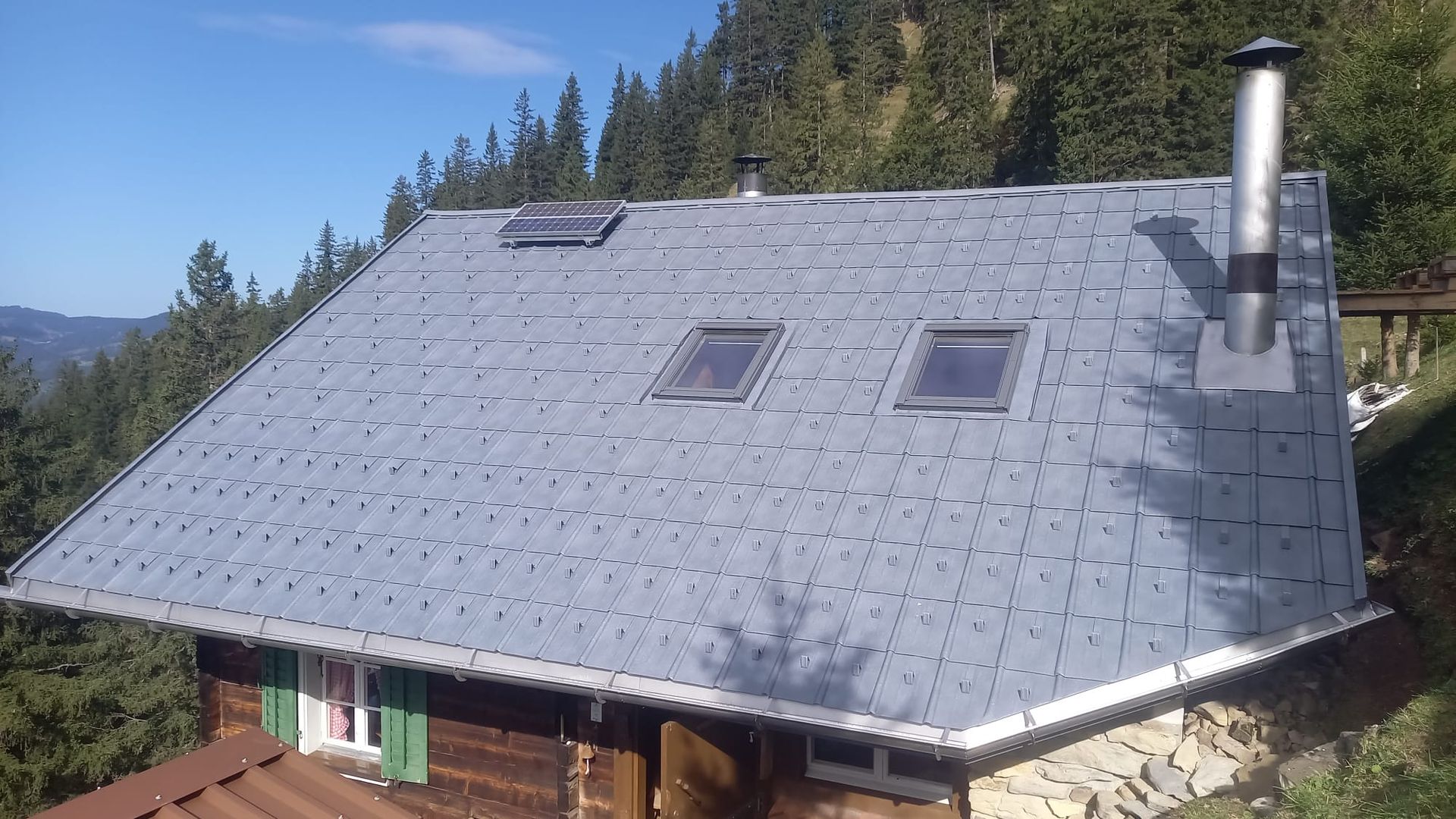 Ein Mann kniet auf einem Dach und arbeitet daran, Sepp Wagner GmbH