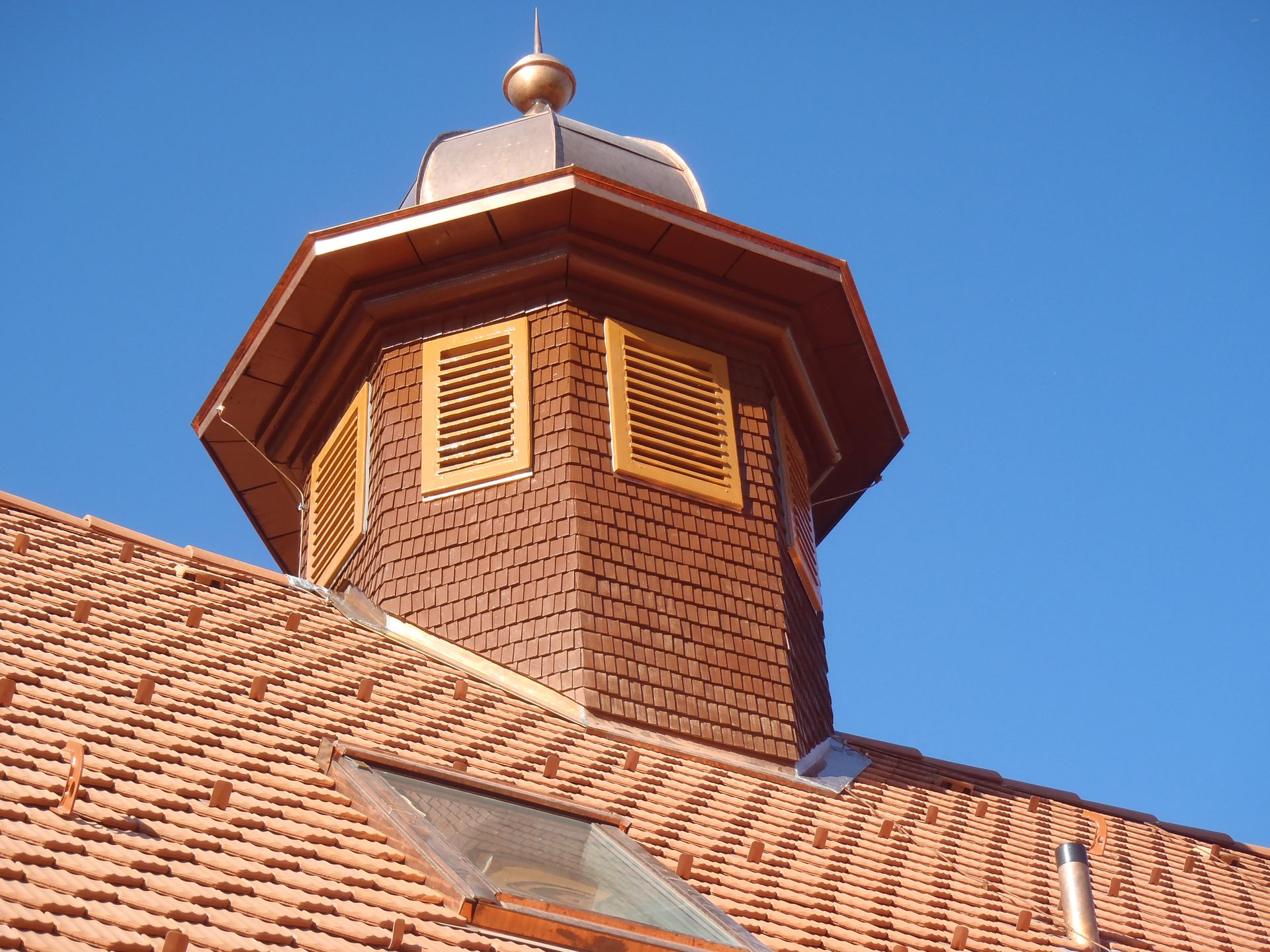 Ein Mann auf einer Leiter arbeitet auf dem Dach eines Hauses, Sepp Wagner GmbH