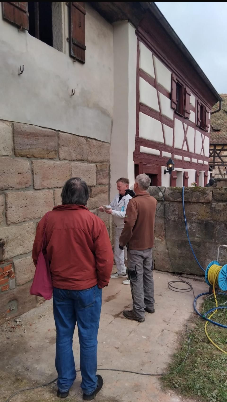 Eine Gruppe von Menschen steht vor einem Gebäude.