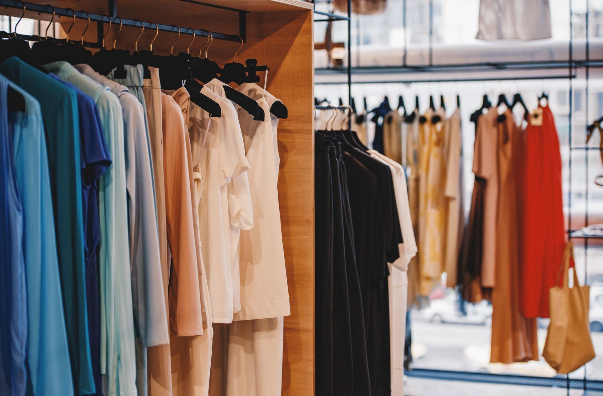 Un armario lleno de ropa colgada en percheros en una tienda.