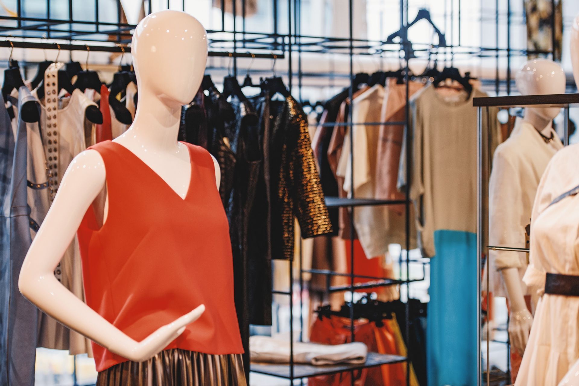 Un maniquí con una camiseta roja está de pie en una tienda de ropa.