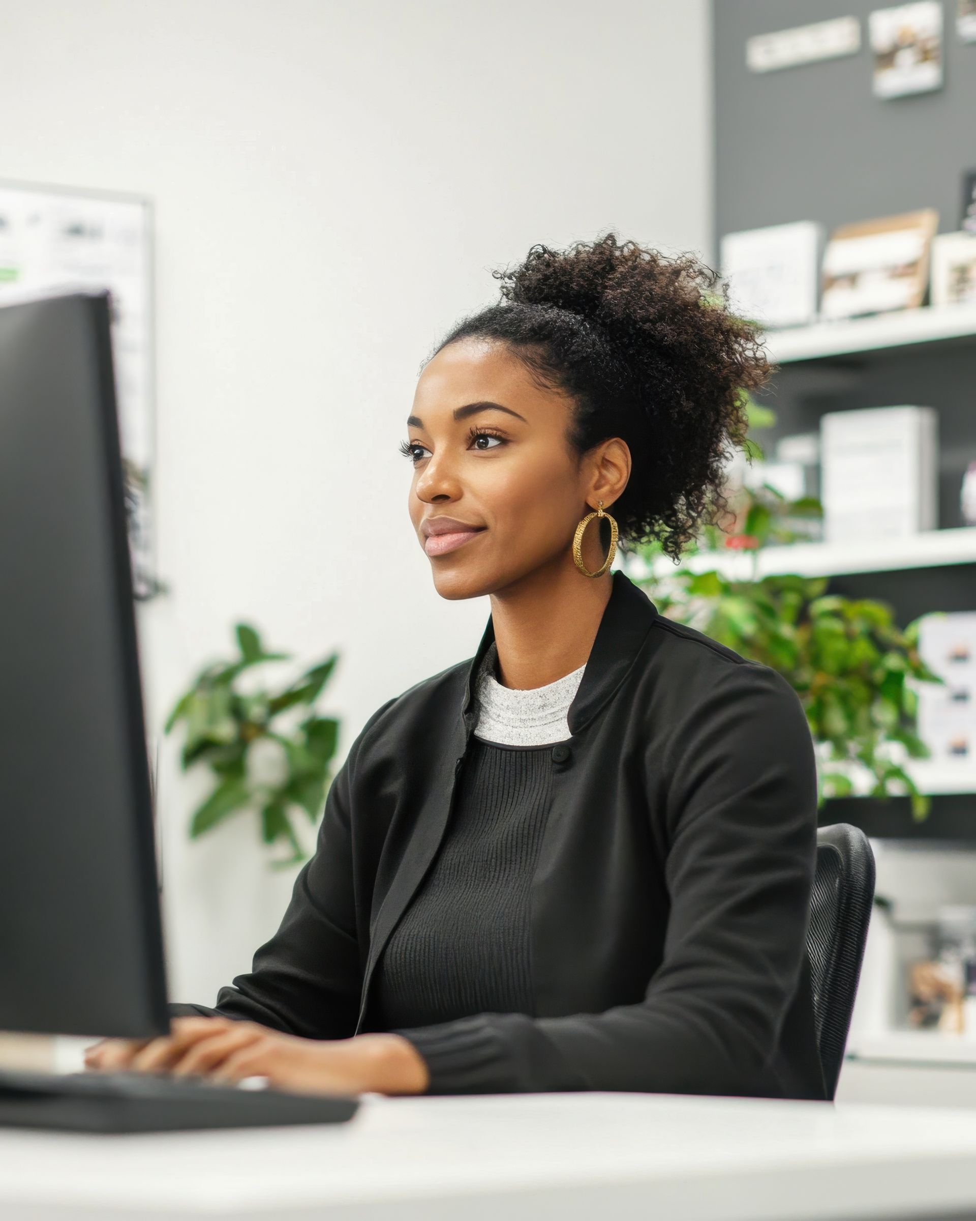 Femme aux cheveux noirs bouclés travaillant sur un ordinateur