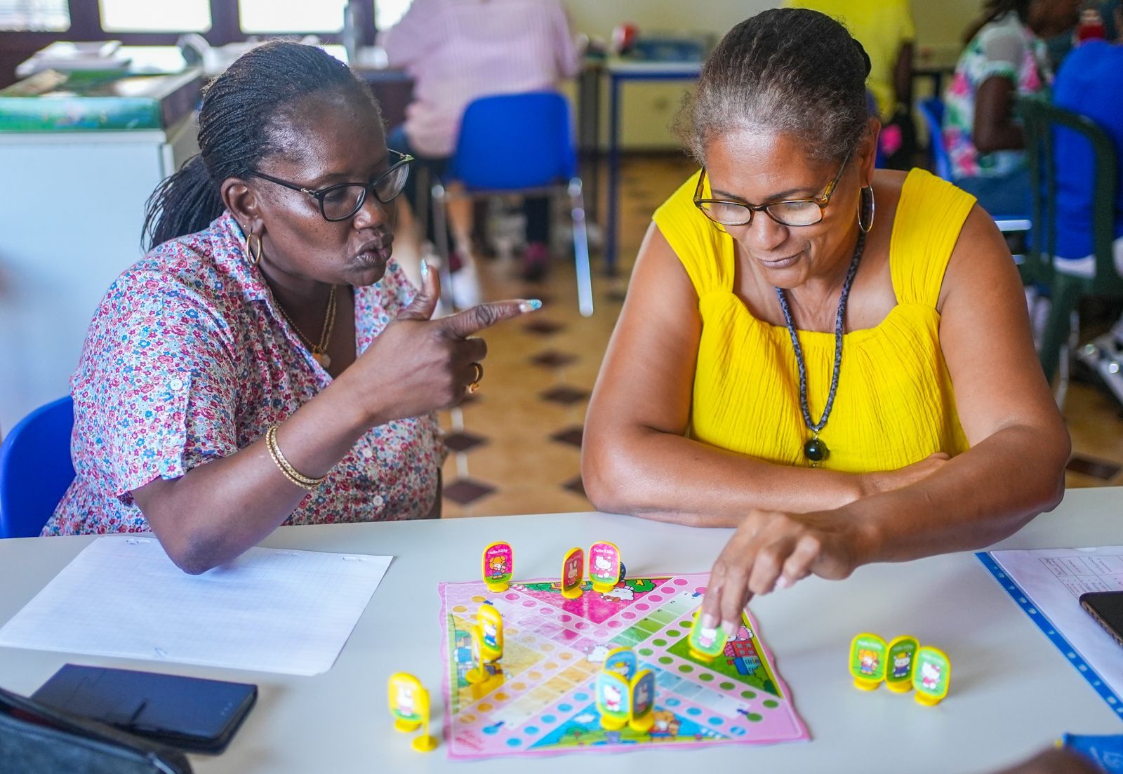 Deux femmes jouent à un jeu de société autour d'une table
