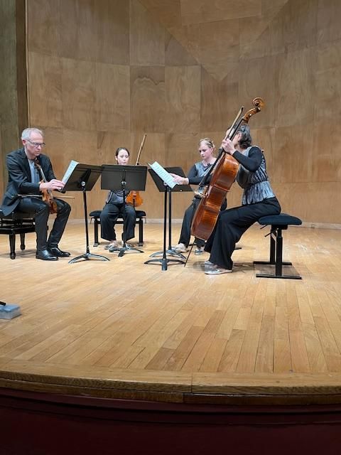 Quatre musiciens interprétant de la musique classique sur scène.