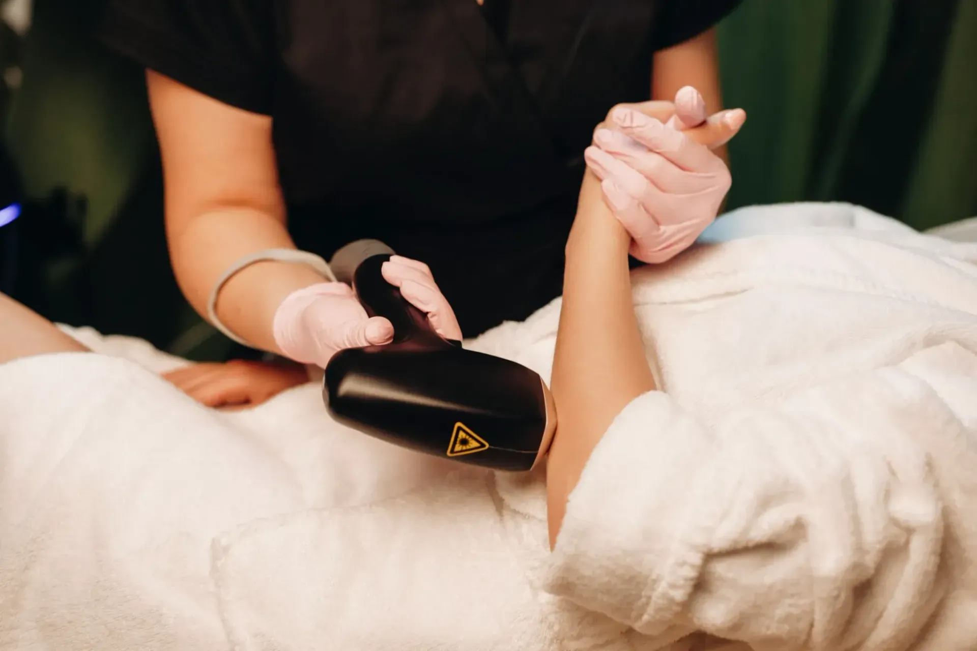 Brazo de una persona que recibe un tratamiento de depilación láser en un spa.