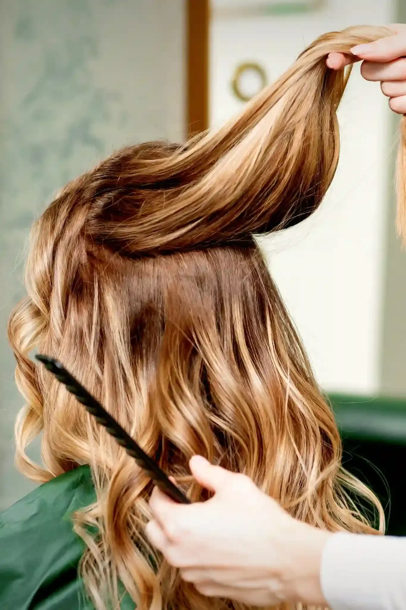 Balayage y con mechas de una mujer con un peine en un salón.
