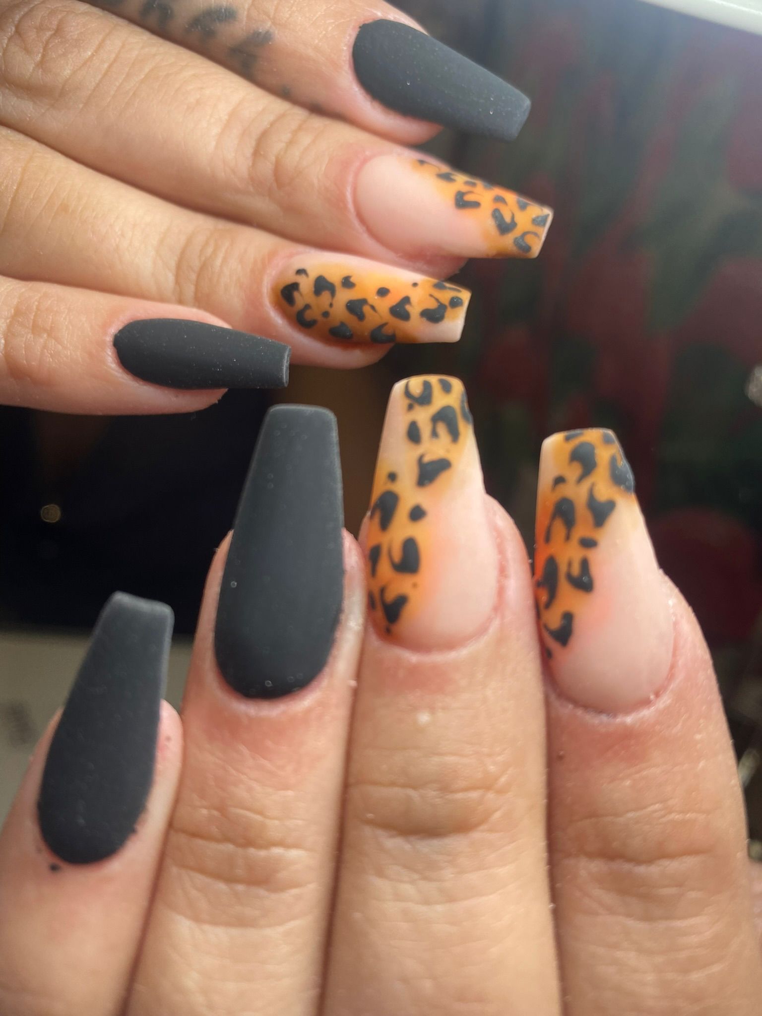 Manos con uñas largas, puntiagudas y transparentes, puntas de brillantina roja.