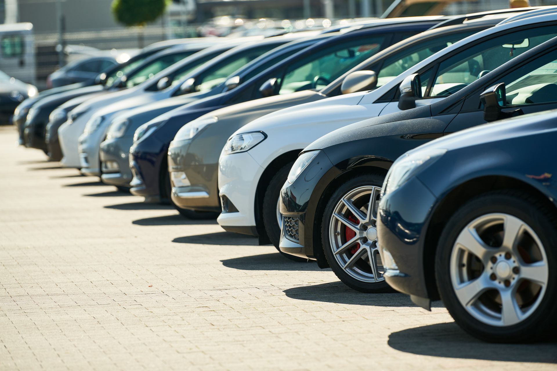 Eine Reihe geparkter Autos auf einem Parkplatz im Freien, die Fronten zur Kamera geneigt.