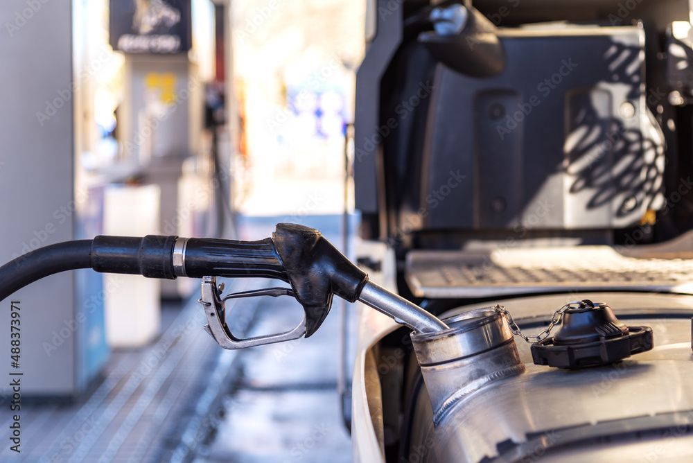 Die Zapfpistole wird an einer Tankstelle in den Benzintank eines Autos eingeführt.