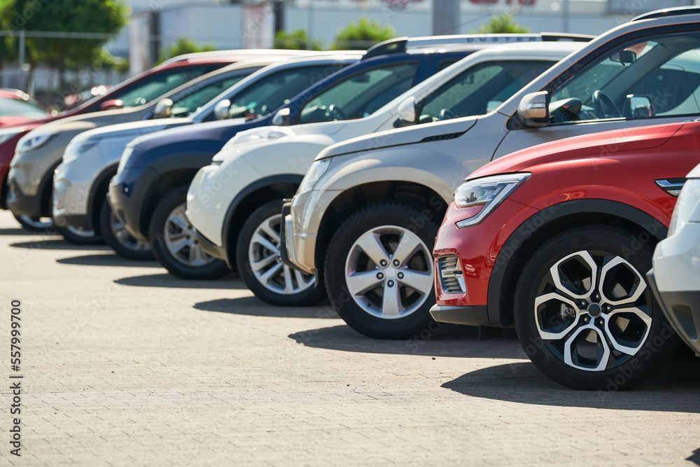 Eine Reihe geparkter Autos auf dem Parkplatz eines Autohändlers, darunter ein roter SUV im Vordergrund