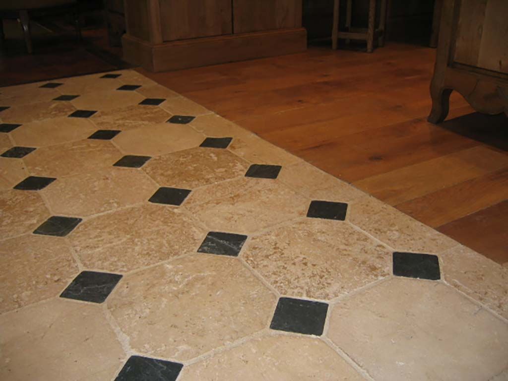 Des carreaux octogonaux beiges, rehaussés de petits carreaux carrés noirs, bordent un parquet lisse.