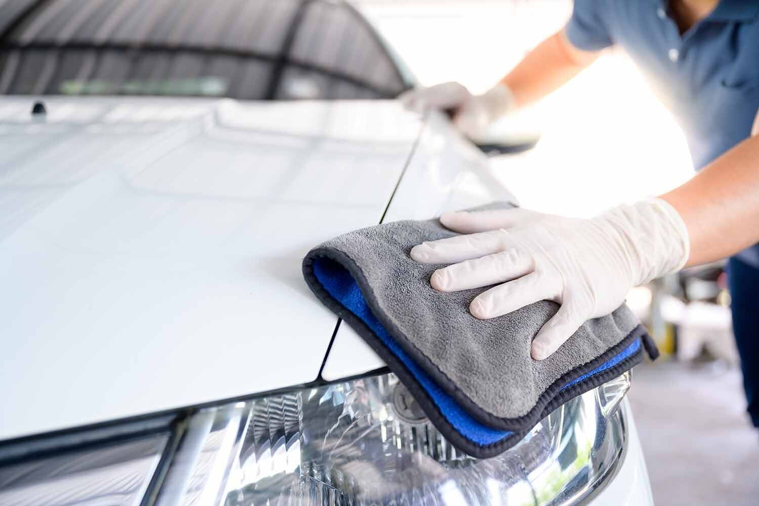 Personne qui lave une voiture blanche