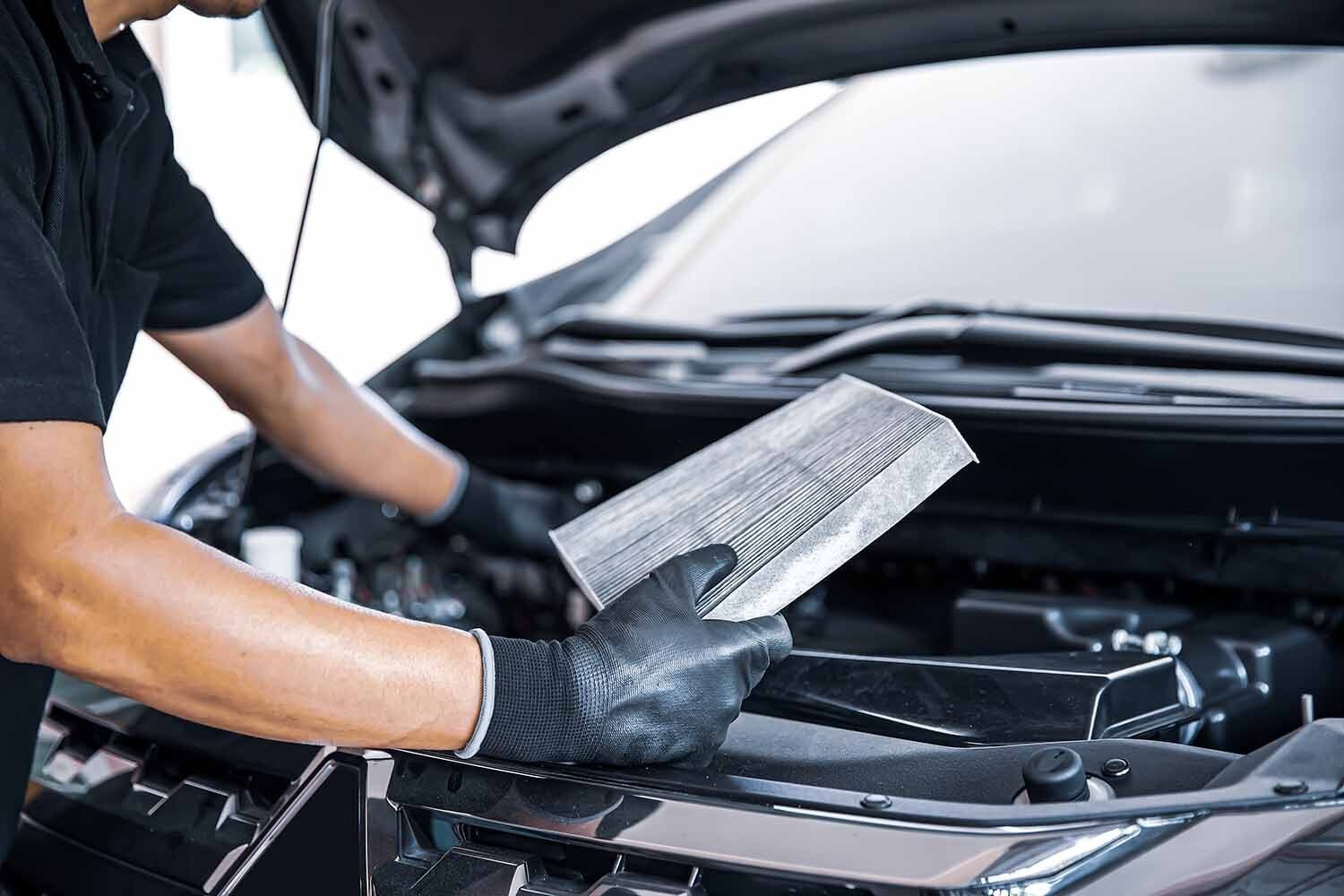 Garagiste avec une clim de voiture dans les mains