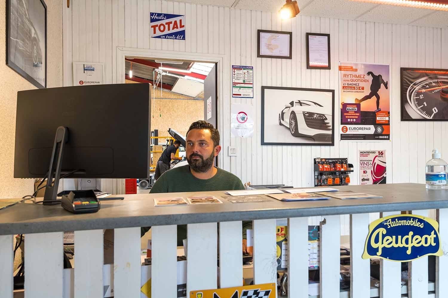 Homme derrière un bureau qui regarde un PC