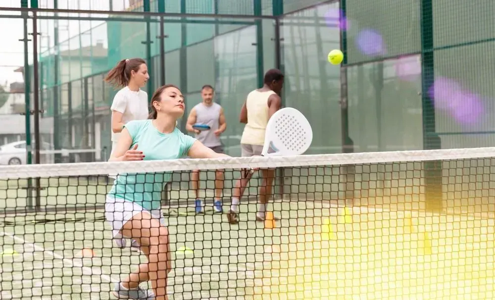 Un grupo de personas está jugando al pádel en una cancha.