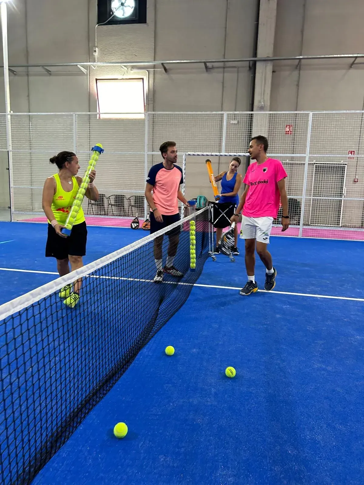 Un grupo de personas está jugando al tenis en una cancha.