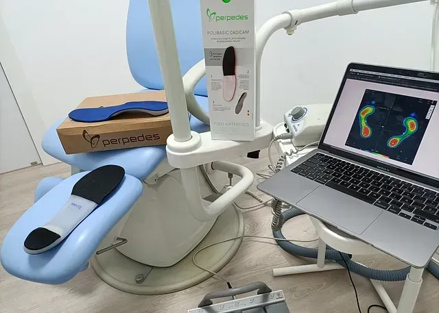Consultorio médico con análisis de presión del pie. Una computadora portátil muestra un escáner del pie, plantillas y el empaque del producto.