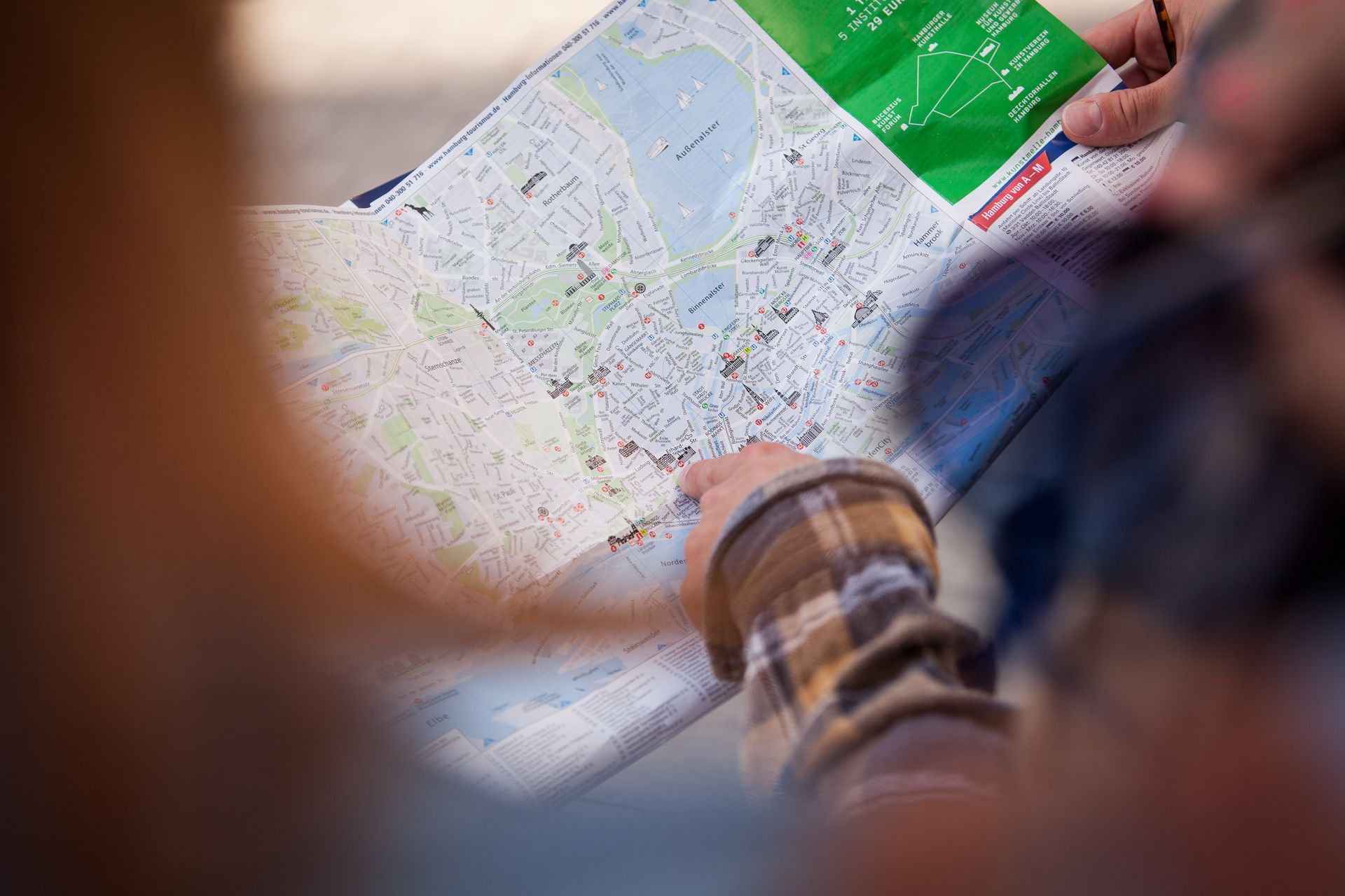 Menschen, die im Freien eine Karte betrachten und karierte Hemden tragen.