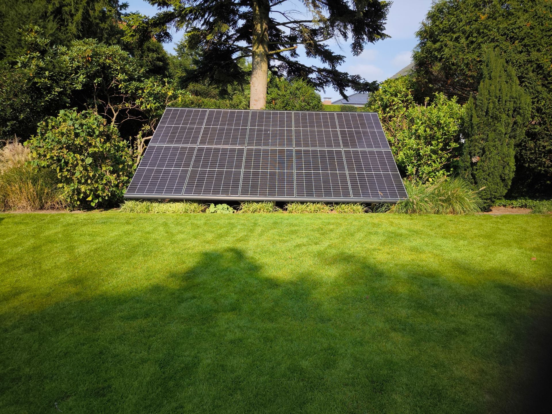 Ein großes Solarpanel befindet sich inmitten eines üppigen grünen Feldes