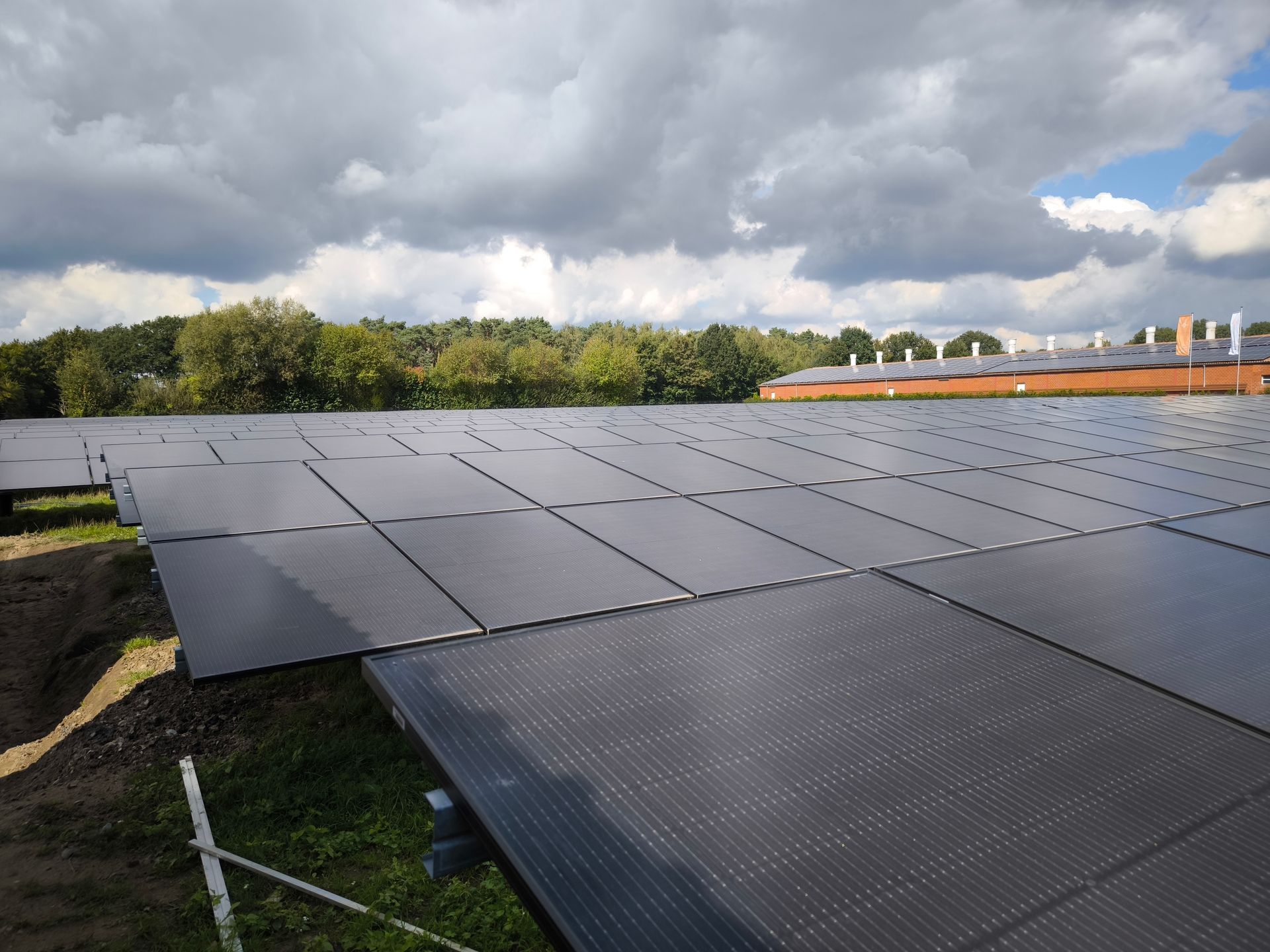 Ein großes Feld aus Solarmodulen mit einem bewölkten Himmel im Hintergrund.