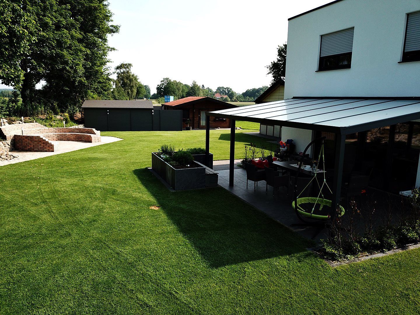 Ein Zaun mit ein paar Büschen und Steinen davor