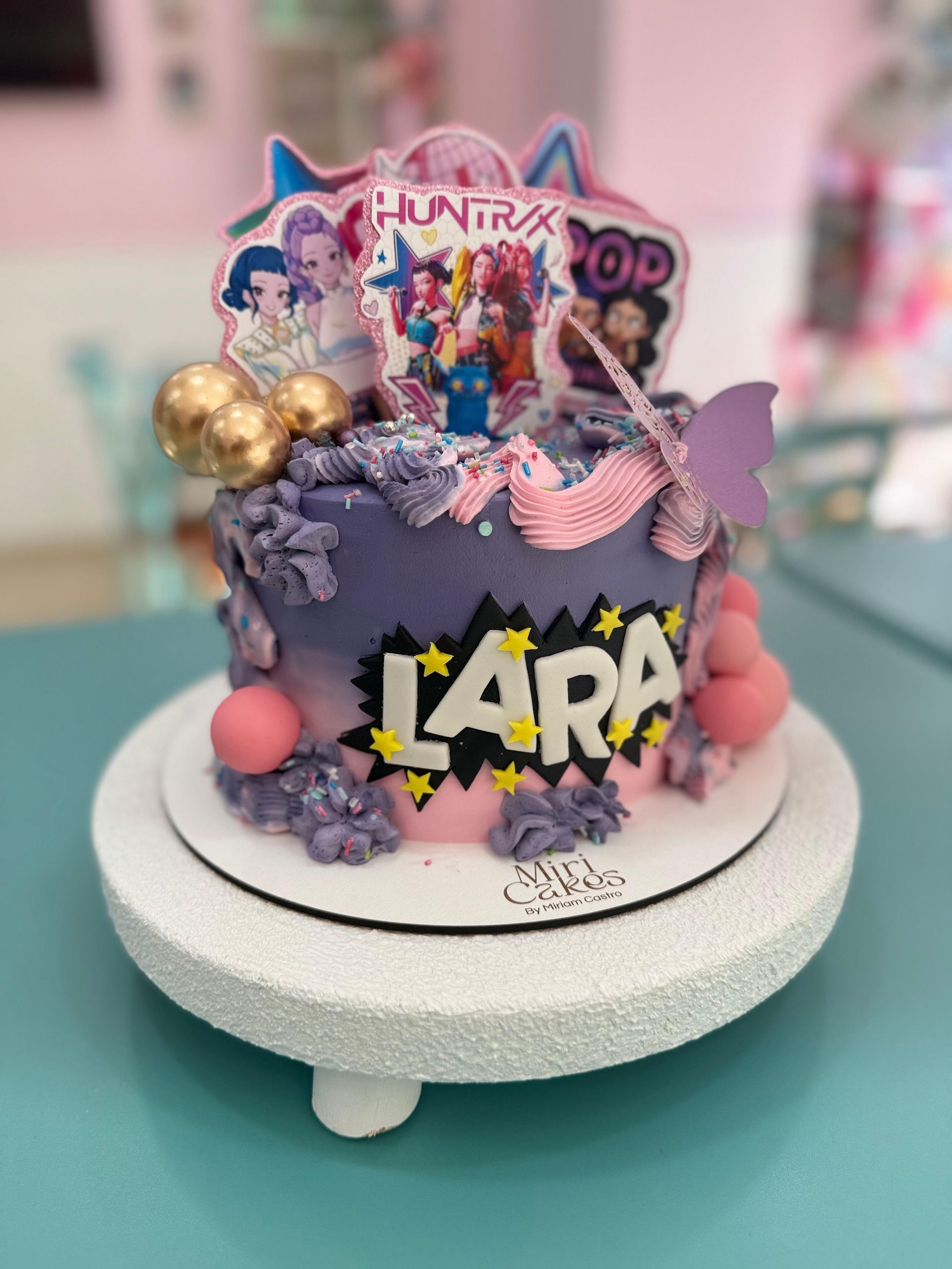 Pastel de cumpleaños con glaseado morado y rosa,