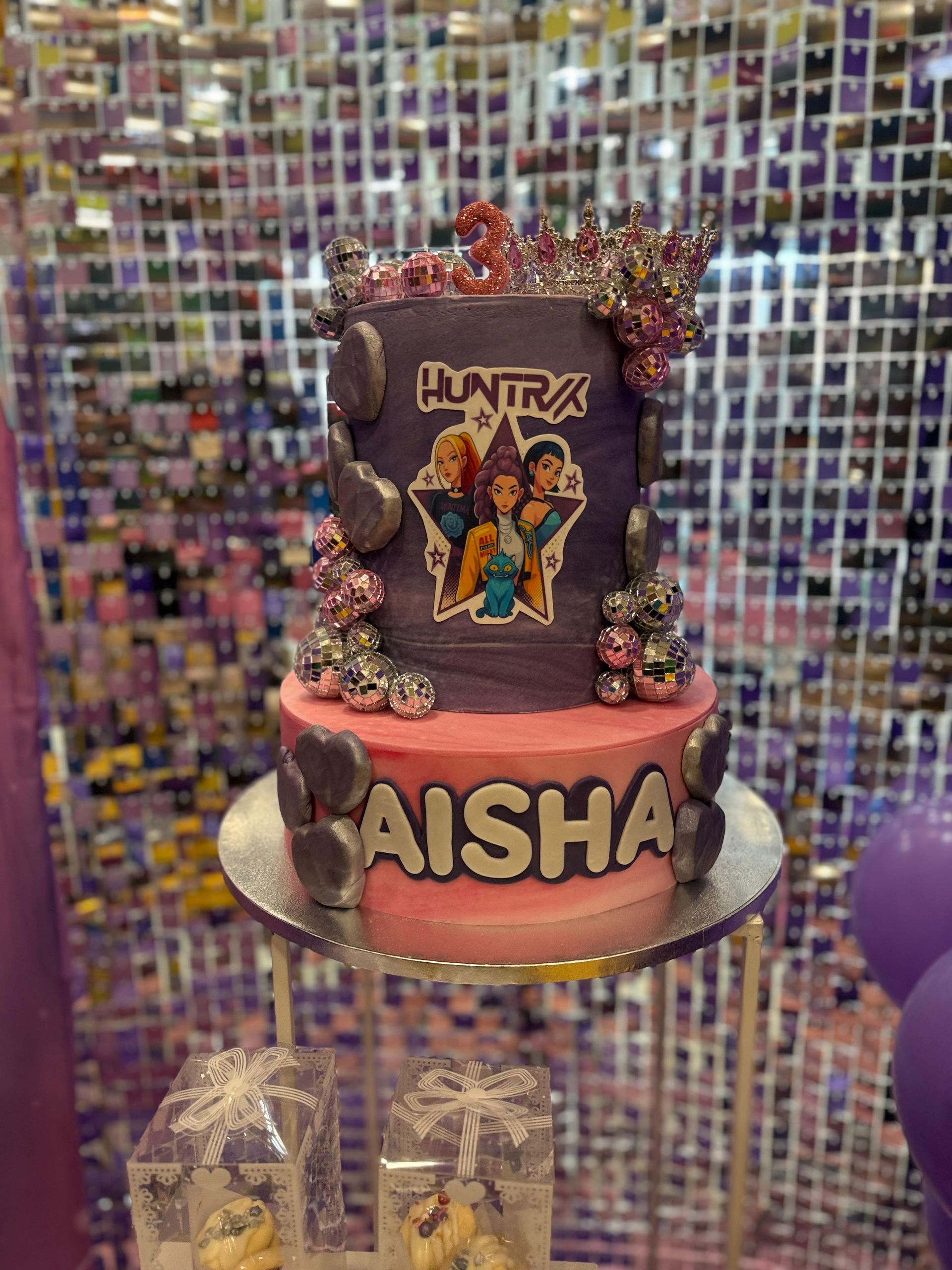 Pastel de cumpleaños con un diseño ombré en tonos morados y rosas, decorado con personajes y