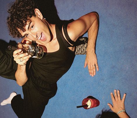 Un hombre está tendido en el suelo sosteniendo una cámara.