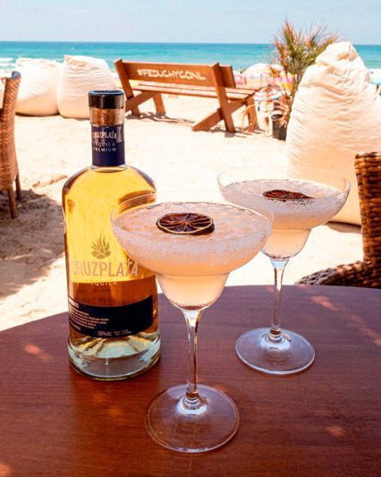 Una botella de cruzplax se encuentra junto a dos copas de martini.