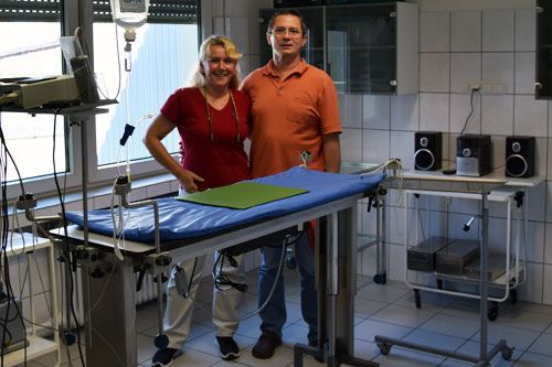 Ein Mann und eine Frau stehen vor einem Operationstisch