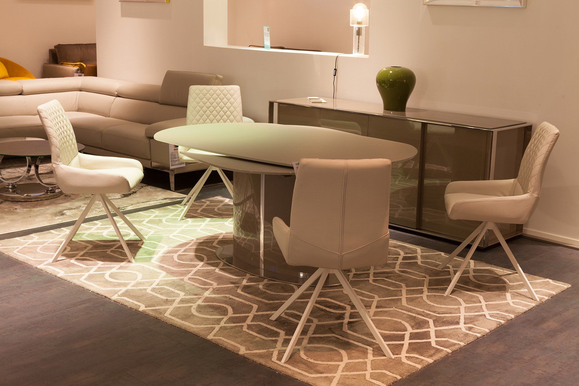 Table de repas ovale et beige avec quatre chaises rembourées blanches