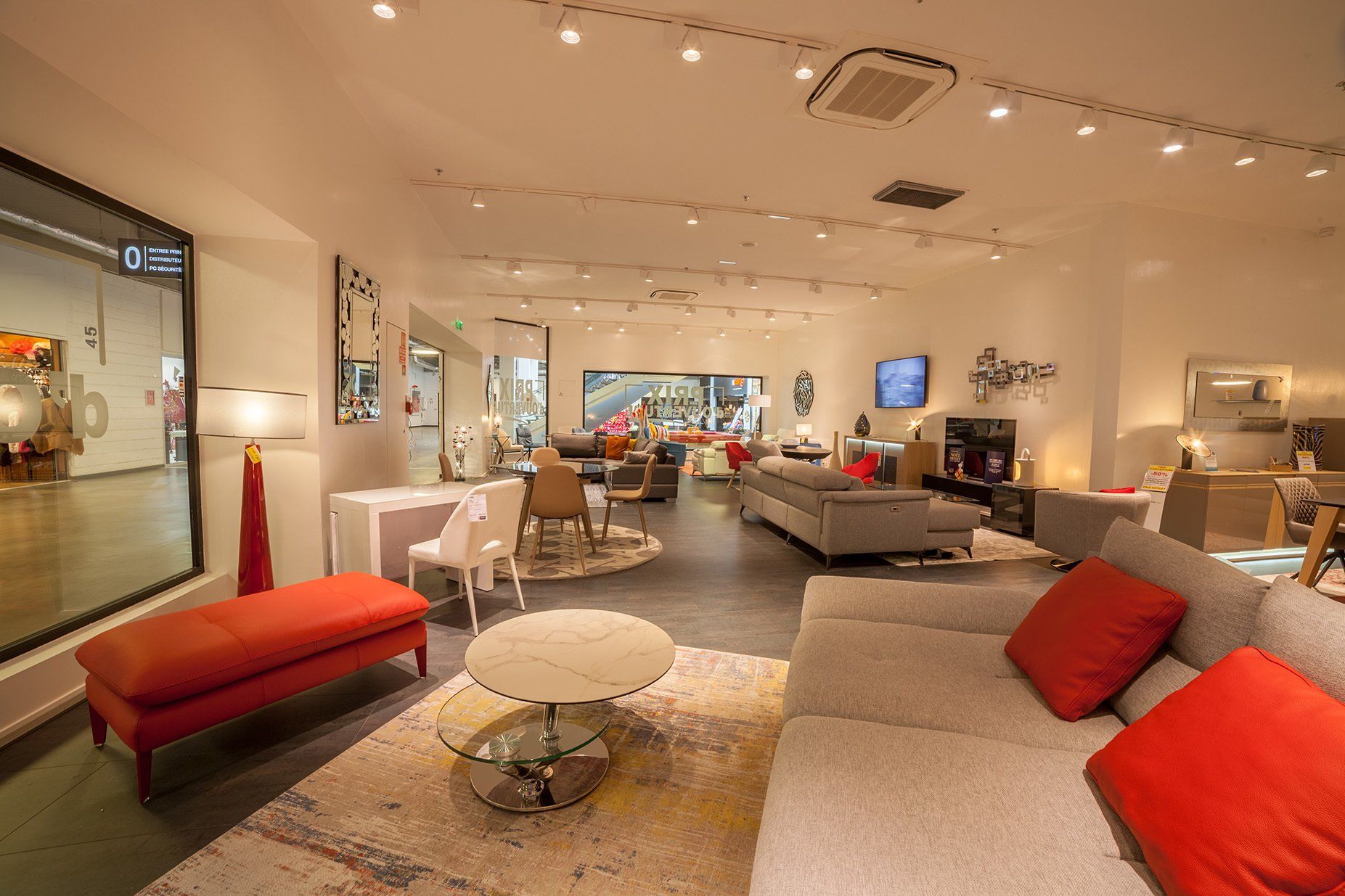 Photo panoramique du magasin Home Center depuis un salon avec tables basses ovales et canapé en tissu