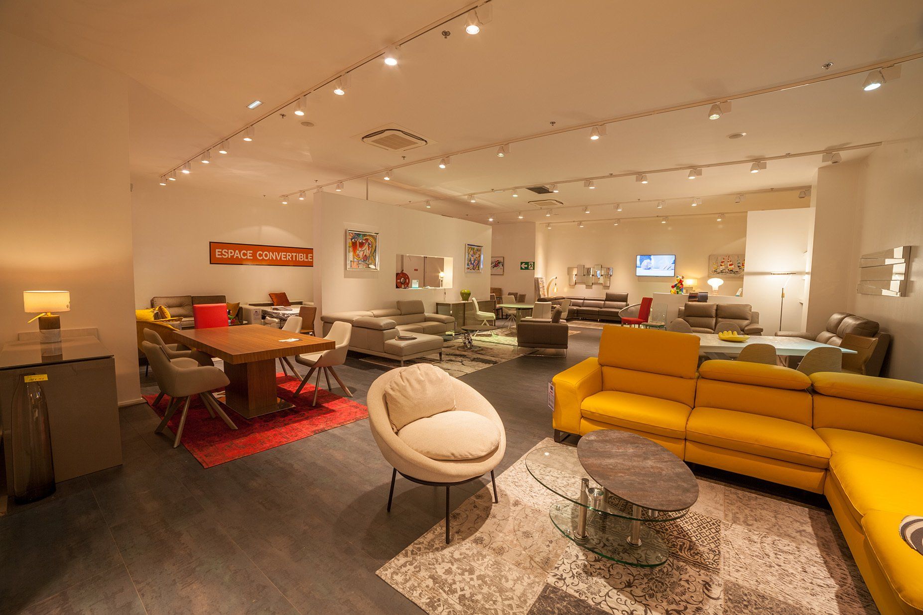 Photo panoramique du magasin avec la représentation d'une salle à manger et d'un salon, avec canapé d'angle jaune