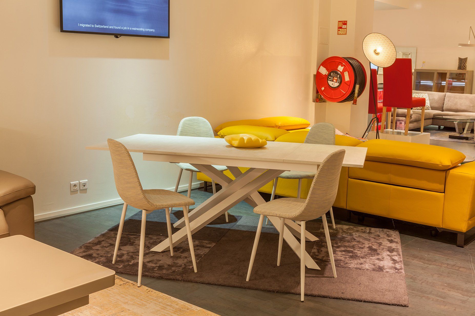 Représentation d'une salle à manger et salon, avec une table blanche, quatre chaises rayées et canapéjaune