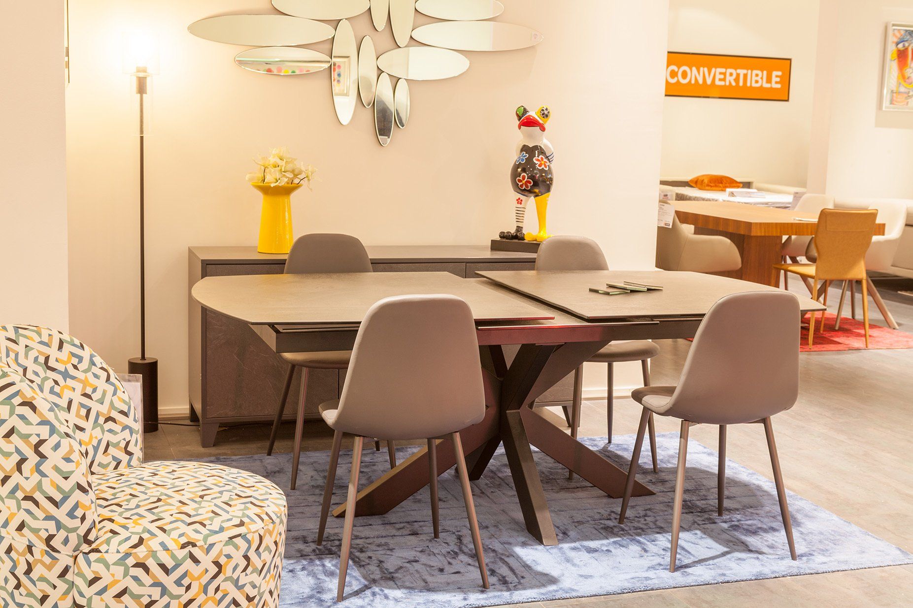 Quatre chaises en tissu entourant une table en céramique extensible