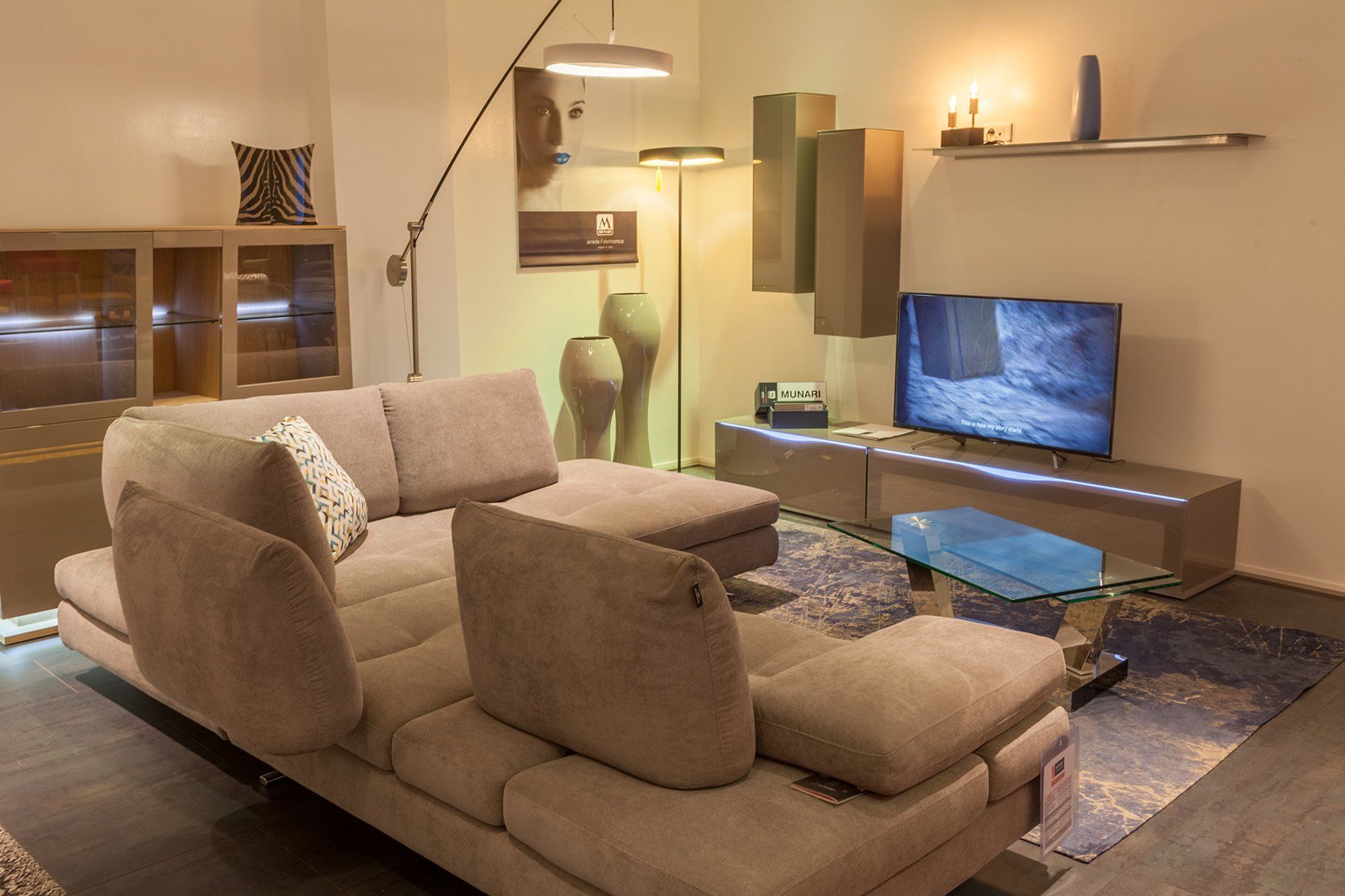 TV allumée dans salon avec canapé gris et dossiers à différents niveaux