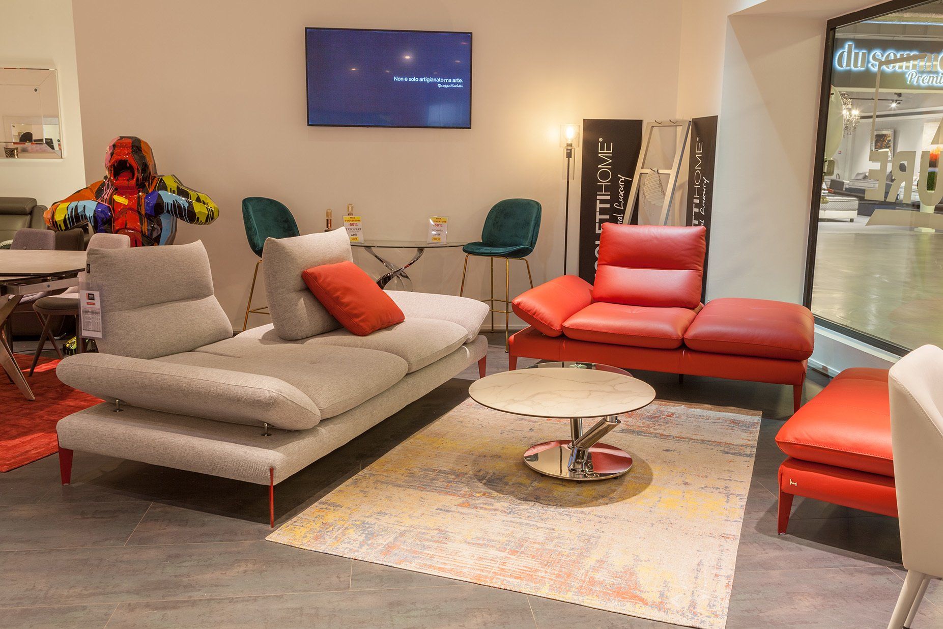 Canapé gris sans accoudoir et canapé rouge en diagonale sans accoudoir