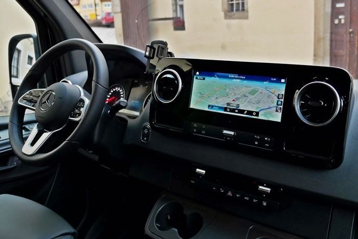 Der Innenraum eines Mercedes Sprinter-Vans mit Lenkrad und Navigationssystem.